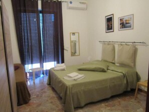 A bedroom with a bed, a mirror, and two pictures on the wall. - Casa Raffaella (Polignano a Mare)