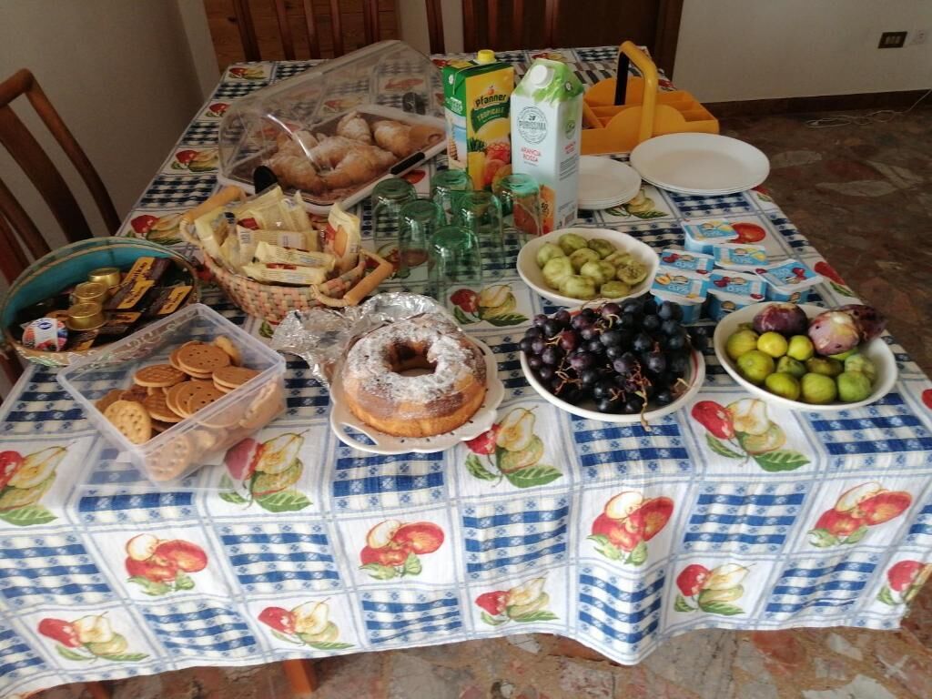 Una mesa dispuesta con diversos alimentos y un cartón de jugo.