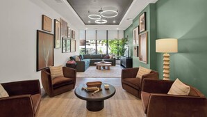 A modern living room with a sofa set, a coffee table, and a lamp. - 1BR Downtown Suite | Pool, Gym & Workspace (Cincinnati)