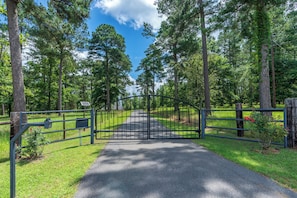 A gated pathway leading into a forested area with tall trees and a clear sky. - Golfers Paradise!! 7- Minutes to Wild Spring Dunes Golf Resort! Sleeps 8! (Mount Enterprise)