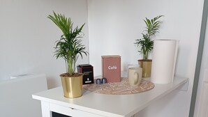 A white desk with two potted plants, a box labeled 'Café,' and a mug. - Cozy room 15 minutes from Paris-Orly with a bathroom and private terrace (Choisy-le-Roi)