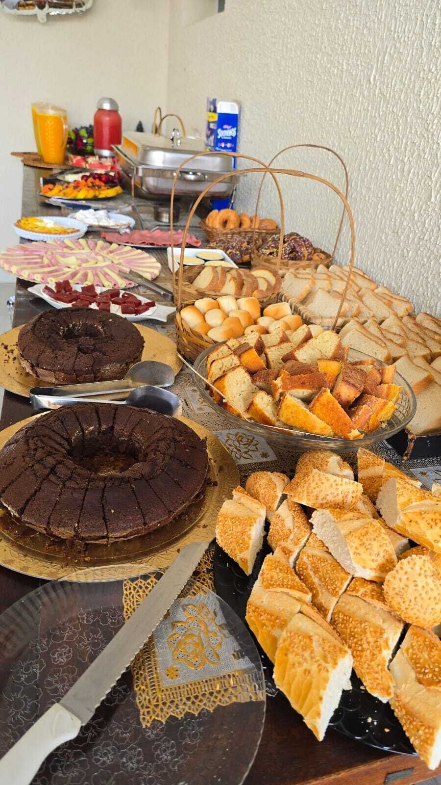 Un buffet con diversi cibi, tra cui torte, pane e frutta.