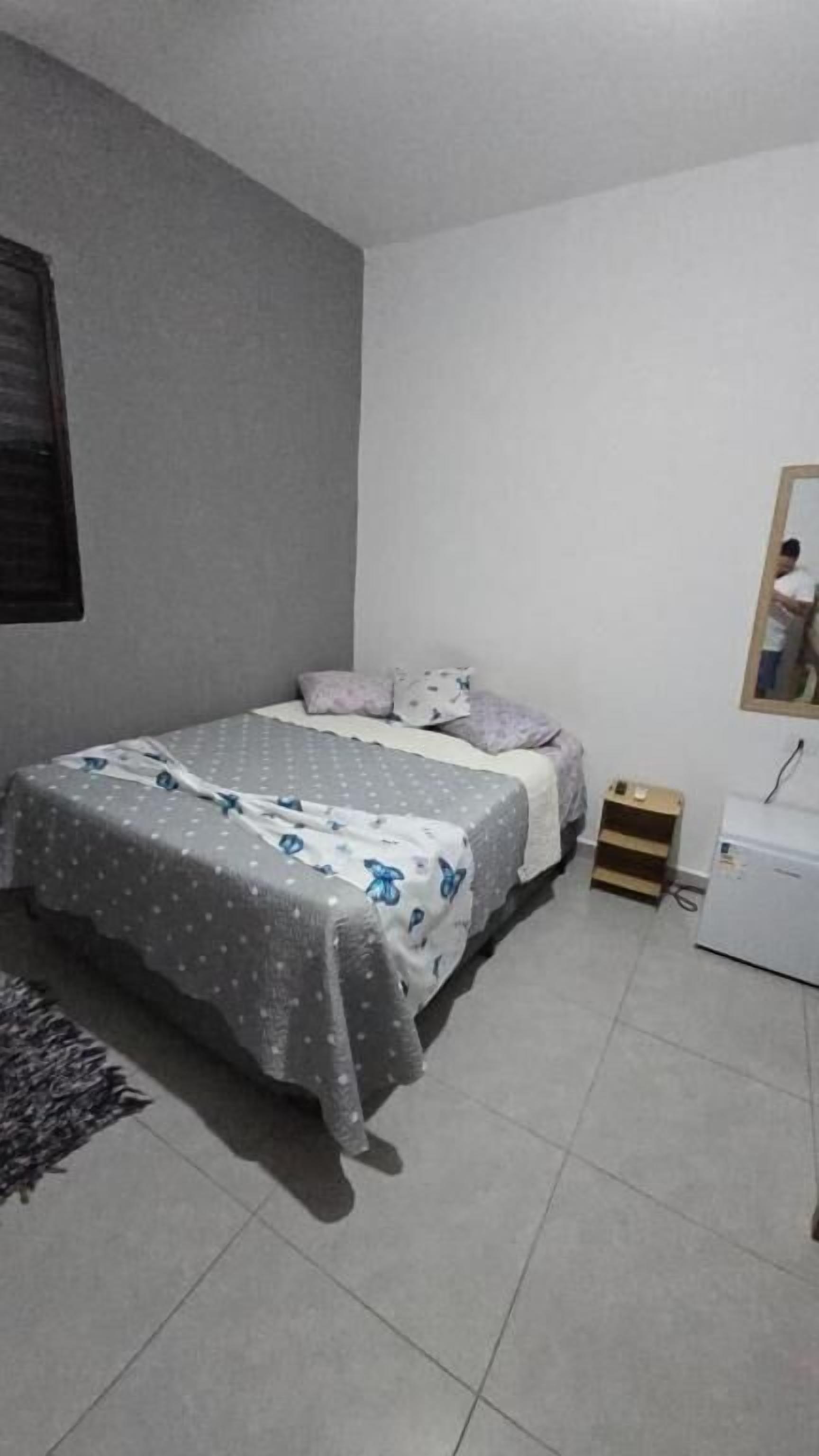 Un dormitorio con cama, cómoda, espejo y ventana.