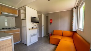 A compact kitchen with a stove, microwave, and a flat-screen TV mounted on the wall. - Holiday Home in Amstelveen With Terrace (Amstelveen)