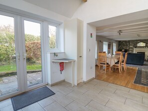 Un interior moderno con comedor, chimenea y vistas al exterior.