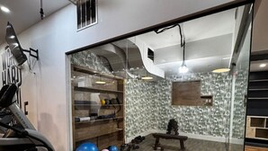 A gym with exercise equipment, a mirrored wall, and a patterned wall.