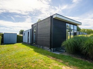 A modern two-story building with a flat roof, large windows, and a well-maintained lawn. - Cube Exclusive 4 (Breskens)