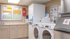 A laundry facility with washers and dryers, a map on the wall, and a fire extinguisher. - 218 Harbor View Studio for Two Pool & Beach (Galveston)