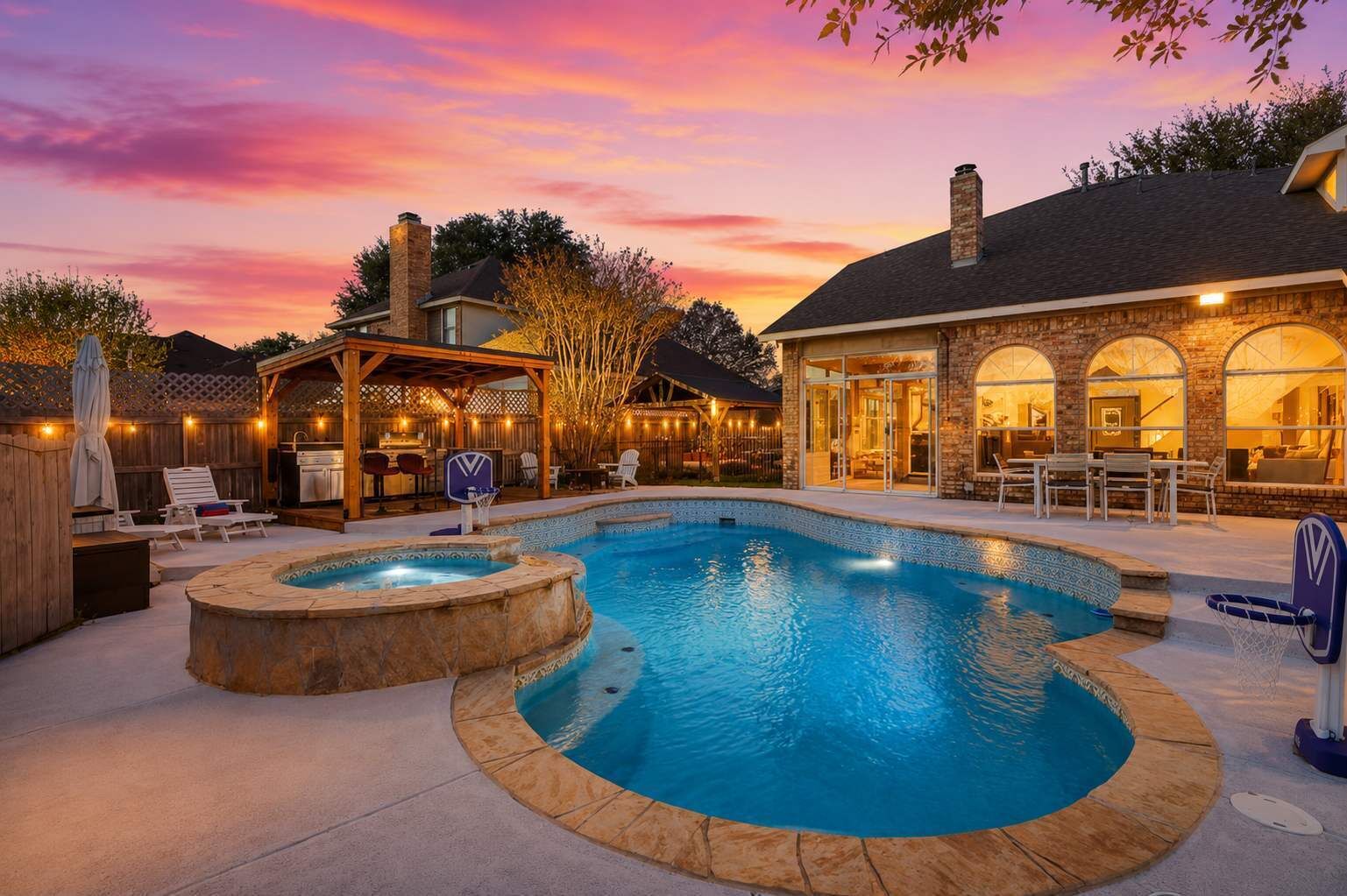A backyard with a swimming pool, a hot tub, and a covered patio area.