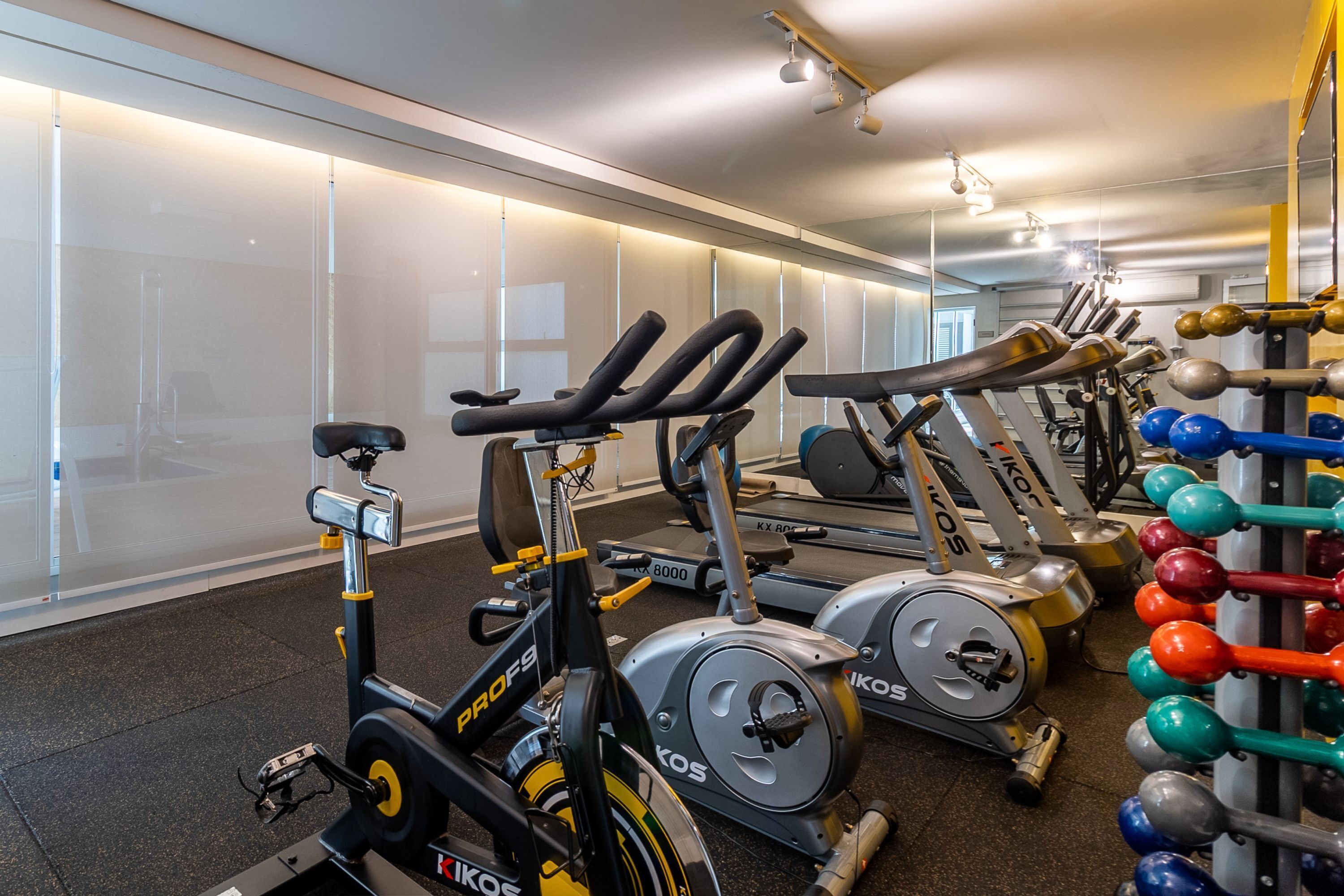 Ett gym med motionscyklar, löpband och en ställning för styrketräning.