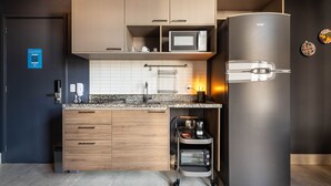 A modern kitchen with a built-in microwave, toaster oven, and a refrigerator. - Jp047 Jacques Pilon Residence 3 Pessoas (São Paulo)