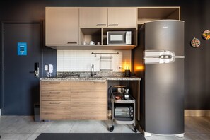 A modern kitchen with a built-in microwave, toaster oven, and a refrigerator. - Jp047 Jacques Pilon Residence 3 Pessoas (São Paulo)