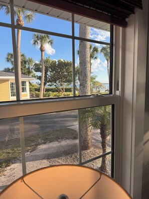 Ein Fenster mit Blick auf Palmen und ein Gebäude.