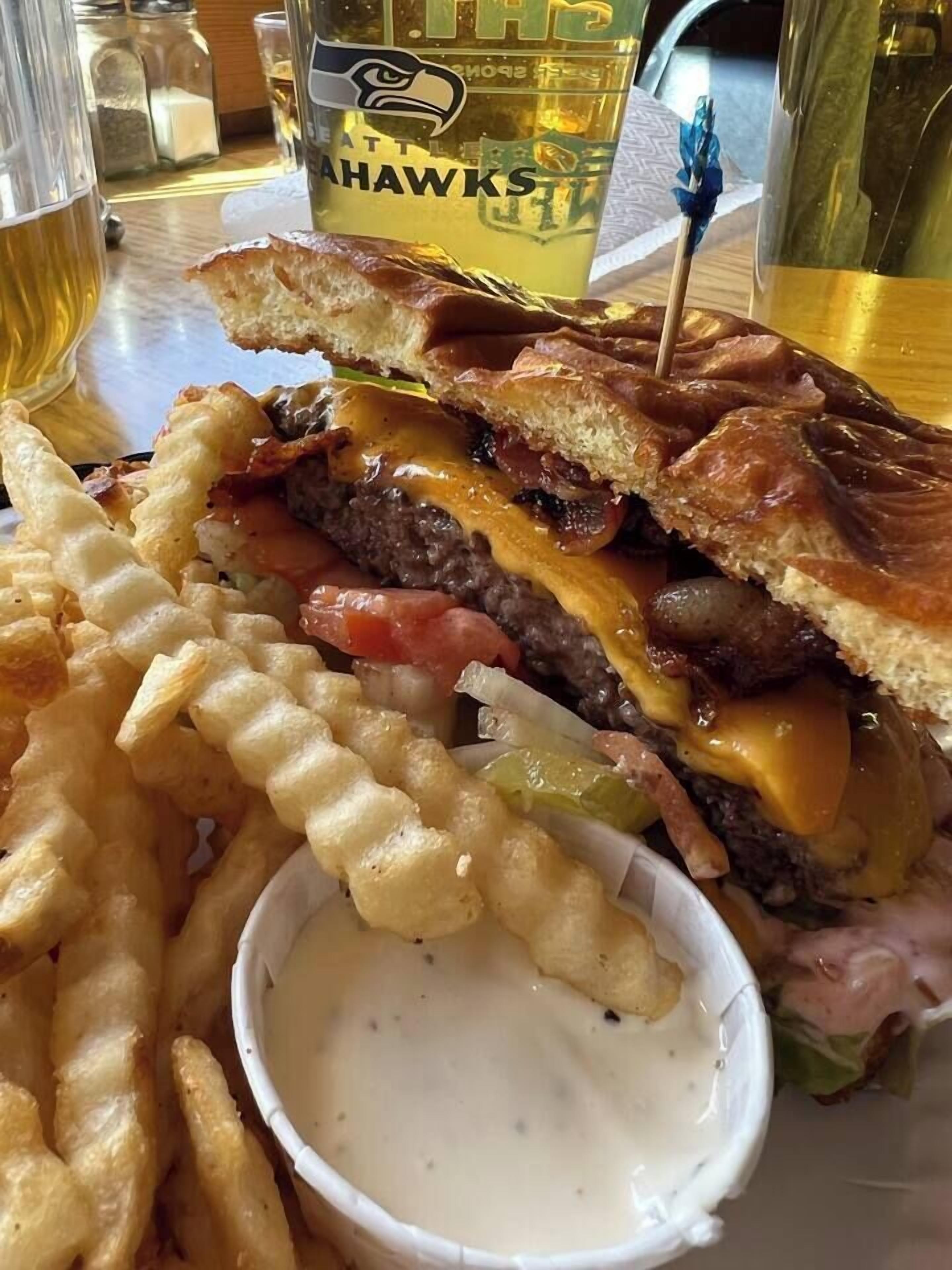A sandwich with fries and a dipping sauce.