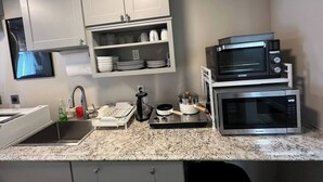 A compact kitchen with white cabinets, a sink, a microwave, and a stovetop. - Hike & Chill, Walk to Coffee Restaurants Bar (Mossyrock)