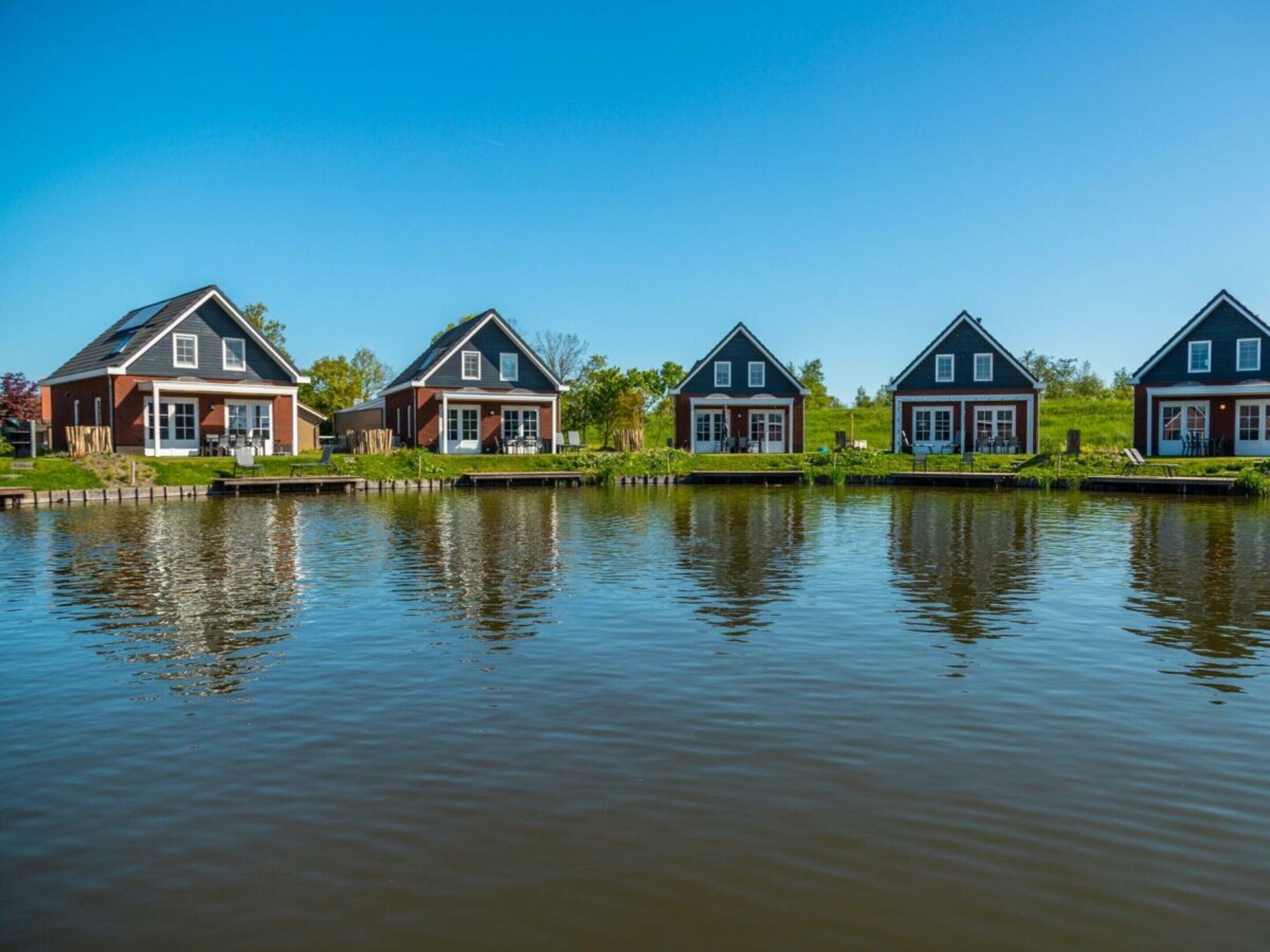 A row of houses by a calm water body.