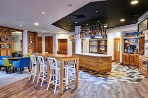 Une cuisine moderne avec des meubles en bois, un îlot central et un coin bar avec des tabourets.