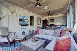 Ein großzügiger Wohnbereich mit Sofa, Sesseln, einem Couchtisch und einem Fernseher.