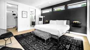 A modern bedroom with a large bed, a bench, a wardrobe, and a desk. - Noir Luxury Home, Design District w/ Pool, Billiard (Miami)