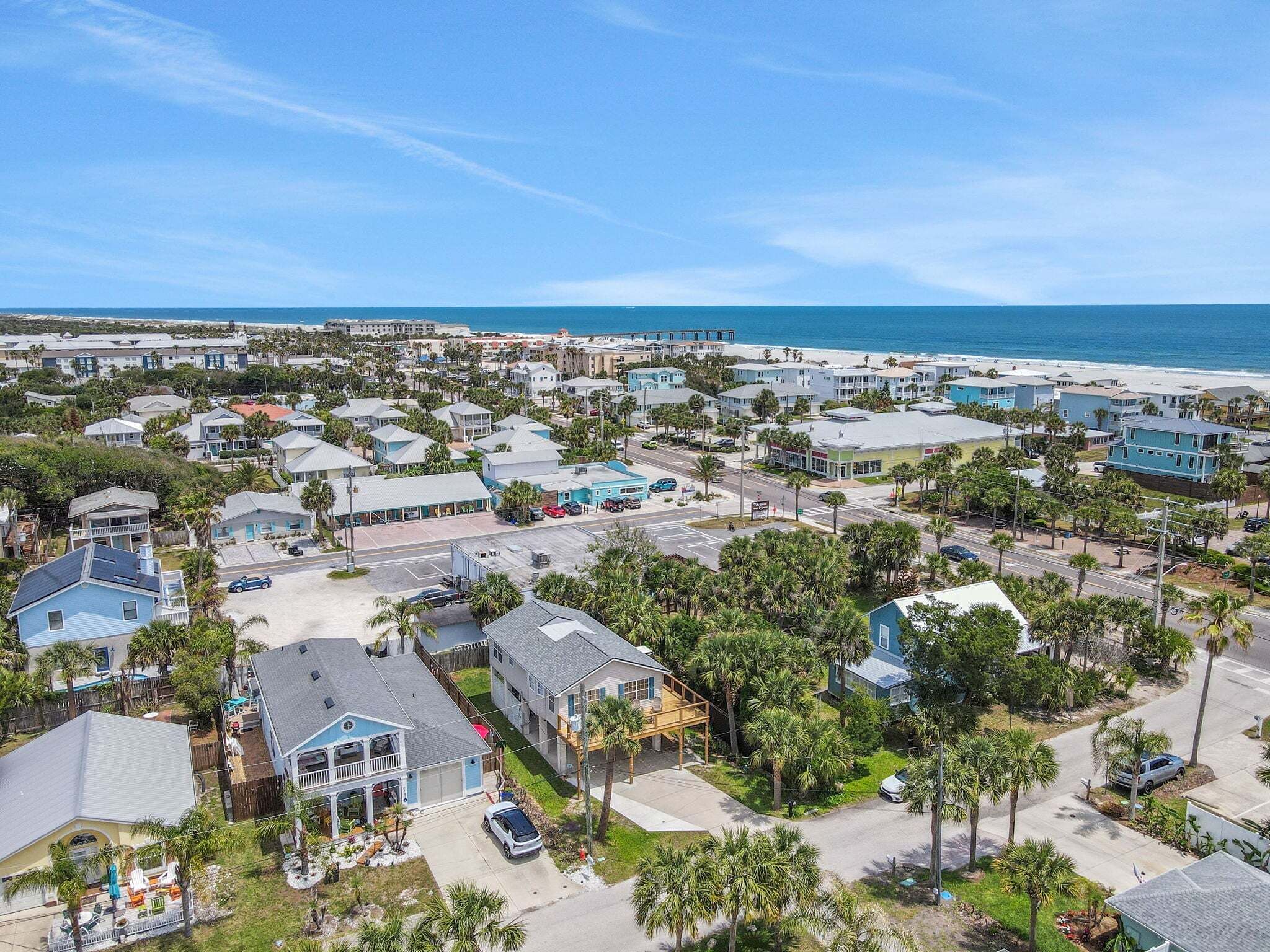 Une zone résidentielle côtière avec des maisons, une plage et un ciel dégagé.
