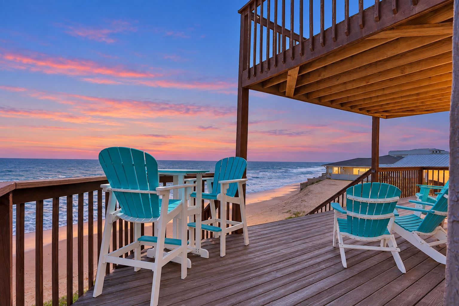A wooden deck with chairs and a table overlooking the ocean at sunset.