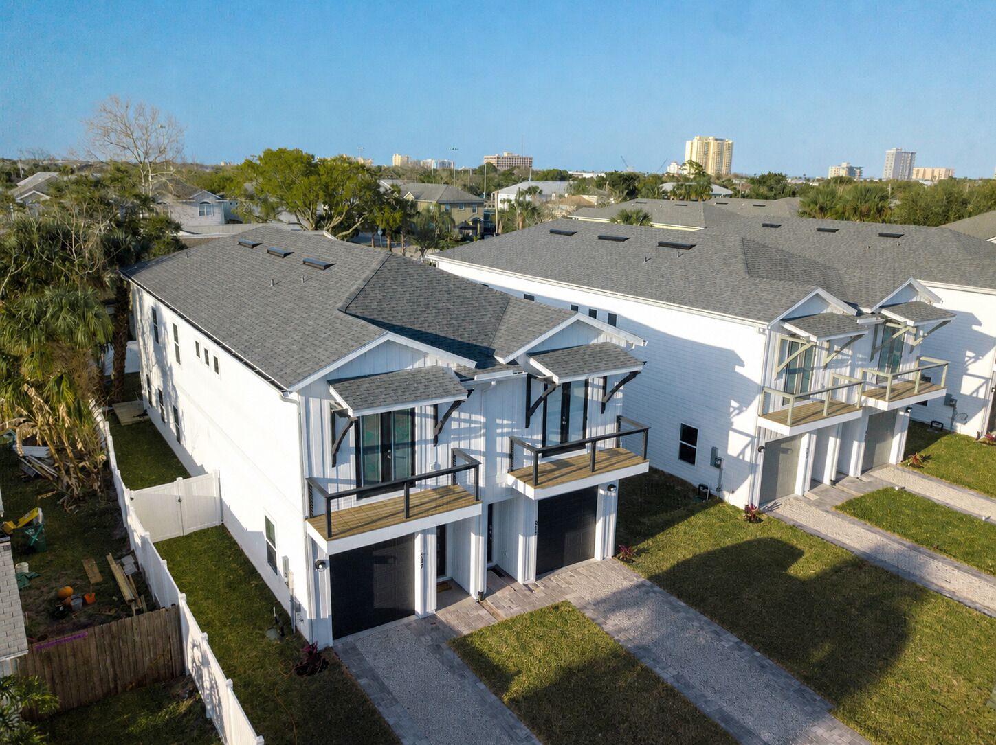 Um edifício residencial moderno com várias unidades, janelas amplas e uma varanda.