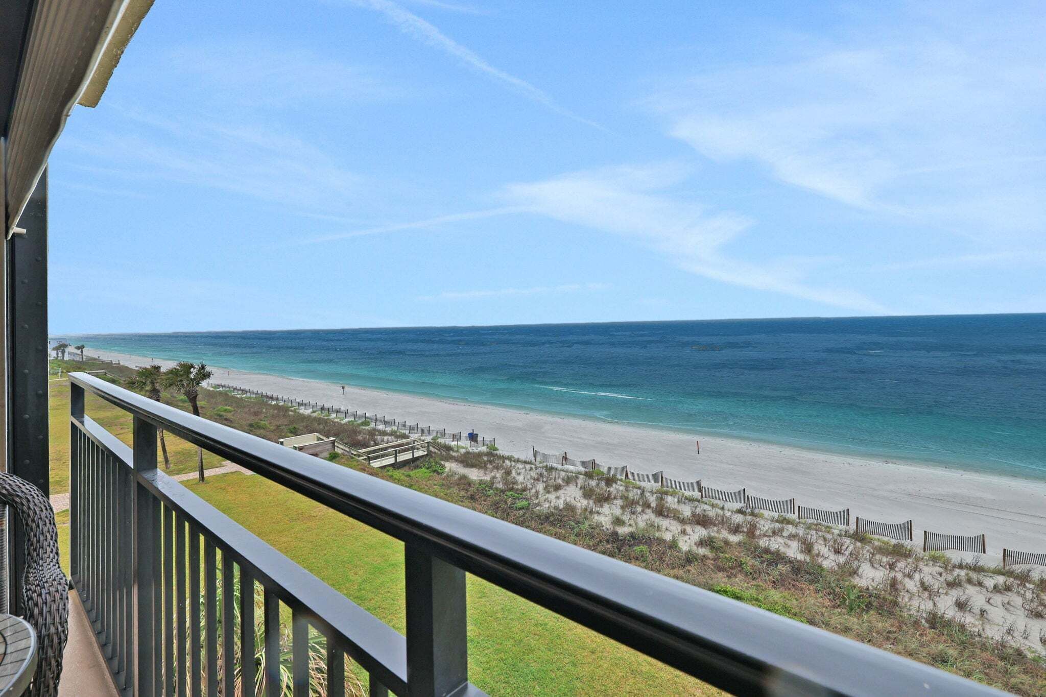 A balcony with a view of a beach and ocean.