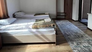 A bedroom with a bed, a wardrobe, and a sliding door to a balcony. - 45 Inn (Tosor)