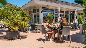 Un patio al aire libre con mobiliario de mimbre y plantas en macetas.