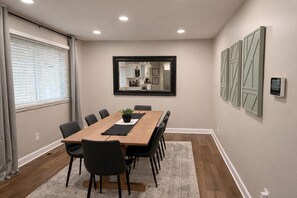 A conference room with a long table, chairs, a potted plant, a mirror, and decorative panels on the wall. - 4BD 2BA Ranch on Catherine Westfield Fenced Yard (Westfield)