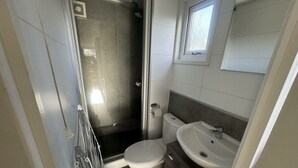 A compact bathroom with a shower, toilet, and sink. - Holiday Home in Susteren With Terrace (Susteren)