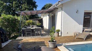 A wooden deck with a pool, outdoor seating, and potted plants. - HOUSE IN THE MEYRAN NEIGHBORHOOD NEAR LA HUME (Gujan-Mestras)