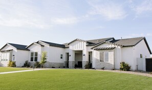 A modern two-story house with a well-maintained lawn, a brick exterior, and a sloped roof. - Artist Residency, Gallery Space & Event Space (Mesa)