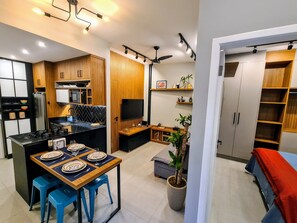 A modern kitchen with a dining area, wooden cabinets, a built-in TV, and a ceiling fan. - Studio do Arquiteto 1 (Rio de Janeiro)