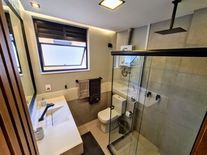 A modern bathroom with a glass-enclosed shower, a white sink, and a toilet. - Studio do Arquiteto 1 (Rio de Janeiro)