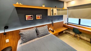 Een moderne slaapkamer met een bed, bureau en raam.