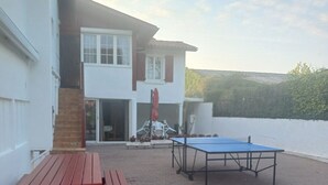 An outdoor patio area with a ping pong table and a picnic table. - Apartment for rent in the Basque Country near the beaches of Biarritz and the mountains (USTARITZ)
