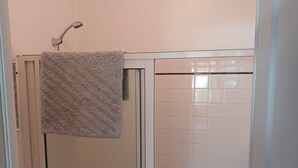 A bathroom with a glass-enclosed shower, a white sink, and a towel hanging on the shower door. - Apartment for rent in the Basque Country near the beaches of Biarritz and the mountains (USTARITZ)