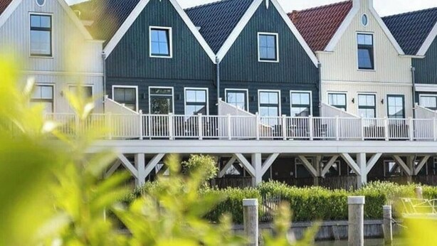 A row of traditional houses with gabled roofs and white railings. - Zuiderzee Sauna 4 (Uitdam)