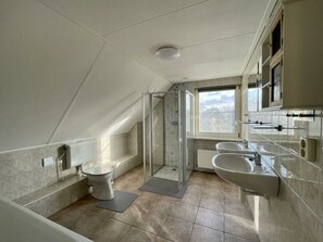 A modern bathroom with a shower, toilet, and two sinks. - Holiday Home in Medemblik With Terrace (Medemblik)