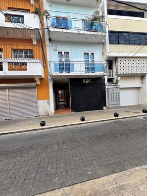 Une vue de rue montrant un immeuble avec un magasin fermé, une enseigne « RBC » et une entrée bien visible.