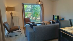 Una sala de estar moderna con un sofá, un sillón y un televisor.