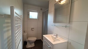 Un baño moderno con inodoro, lavabo y espejo.
