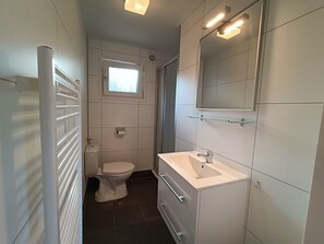 A modern bathroom with a toilet, sink, and mirror. - Holiday Home in Otterlo With Terrace (Otterlo)