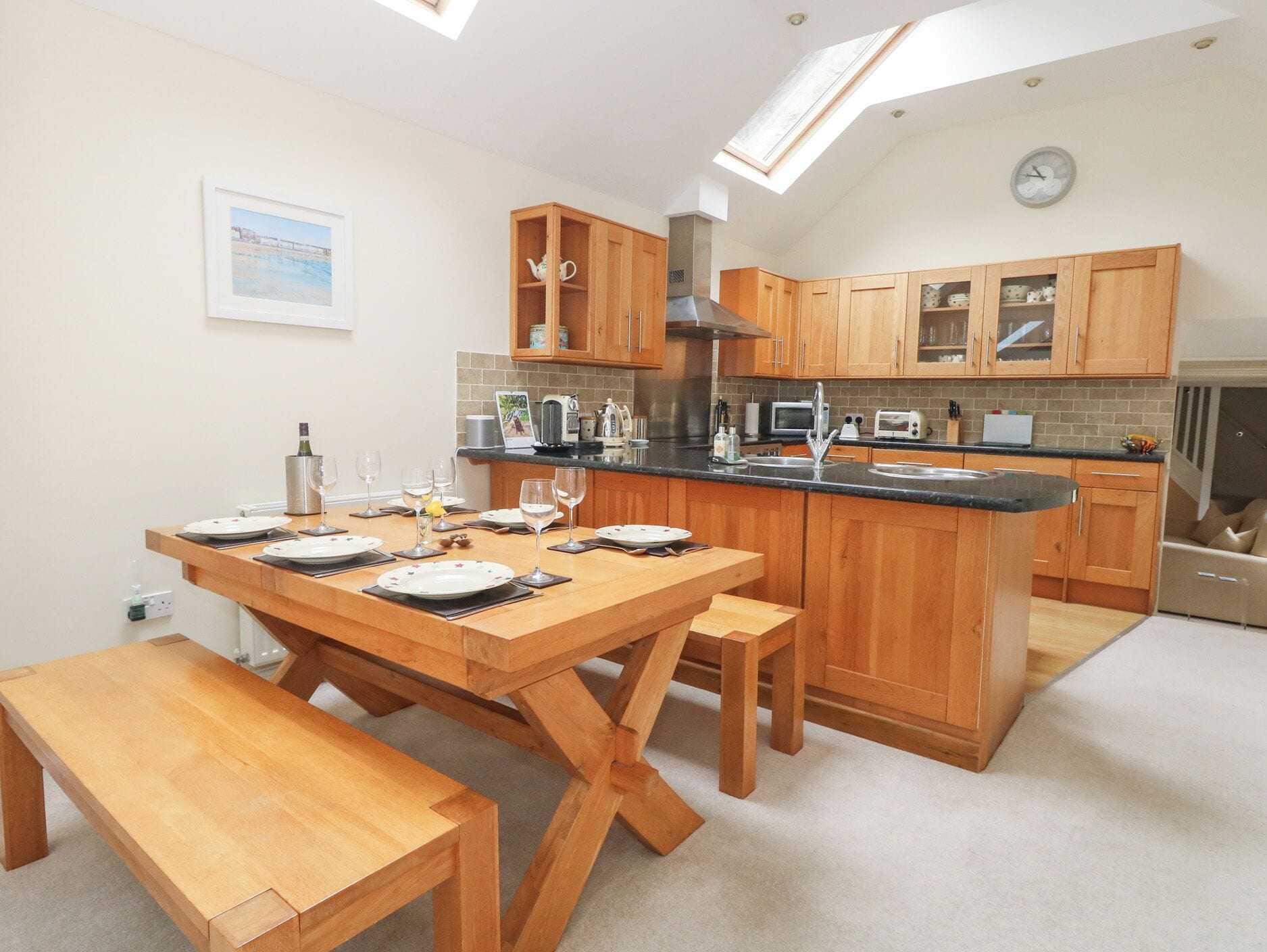 A modern kitchen with wooden cabinetry, a central island, and a skylight.