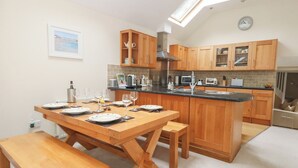 Een moderne keuken met houten kastjes, een centraal eiland en een dakvenster.