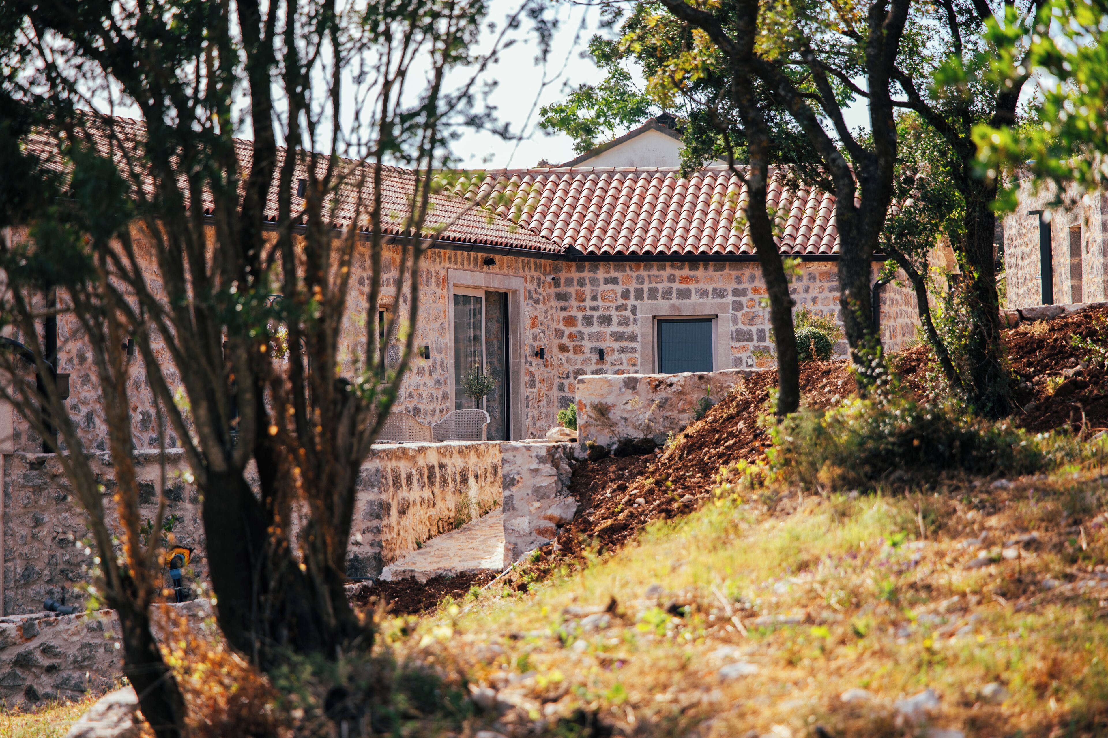Un edificio in pietra con tetto in tegole, una porta e una piccola finestra.