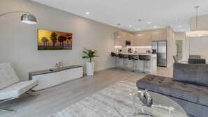 Ein stilvolles Wohnzimmer mit Sofa, Essbereich und Küche.