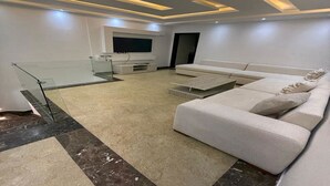 A modern living room with a sofa, TV, and a glass railing.