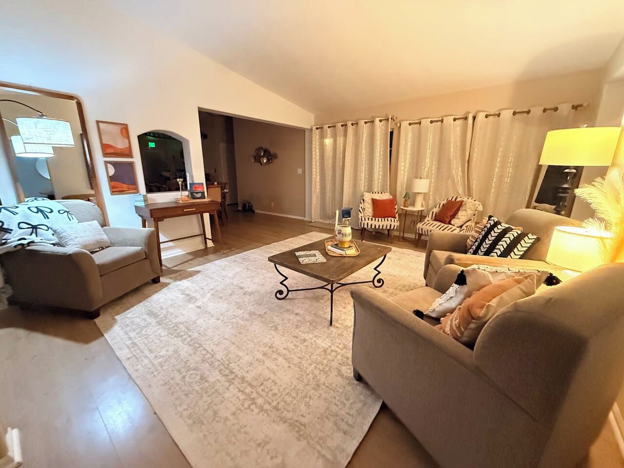 Sala de estar com sofá, poltronas, mesa de centro e abajur.